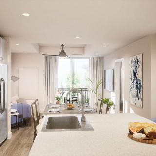 A modern kitchen with an open dining area, featuring minimalist design and neutral colors.