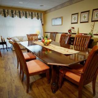 A cozy dining room with a wooden table and chairs set, adorned with a decorative centerpiece.