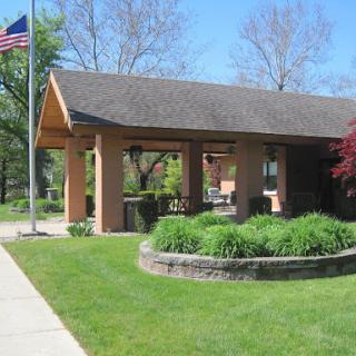 A charming building surrounded by lush greenery and featuring an American flag.