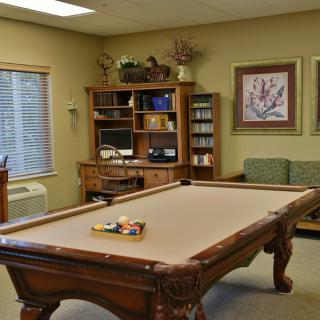 A cozy game room featuring a pool table, television, and comfortable seating.