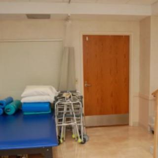 A physical therapy room with exercise equipment and a walker.