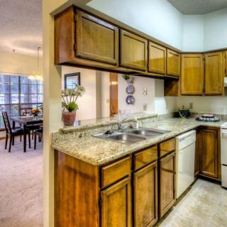 A cozy kitchen with wooden cabinets and a granite countertop.