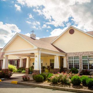 A charming residential building with a well-maintained garden and a clear blue sky overhead.