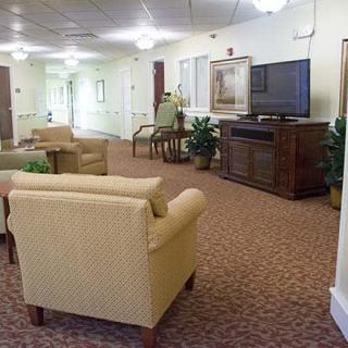 A cozy living room area with comfortable chairs and a TV, along with a view down a hallway.