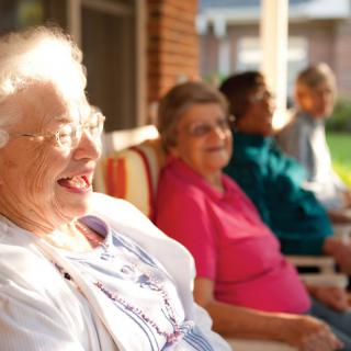 A group of seniors enjoying each other's company on a porch.
