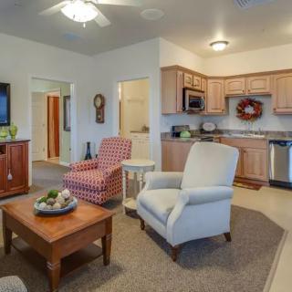 A cozy open-concept living room and kitchen with comfortable seating and warm decor.