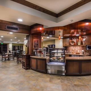 A cozy coffee shop interior with a display of pastries and seating area.