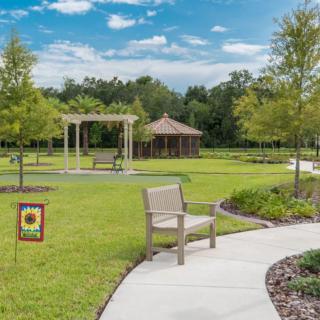 A serene park setting with a gazebo, pathways, and neatly landscaped greenery.
