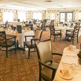 An elegant dining room with neatly arranged tables and chairs.