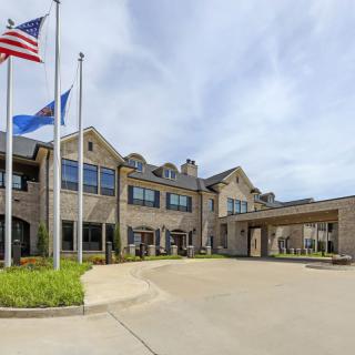 A large building with flags at the entrance on a clear day.