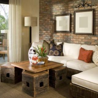 A cozy living room with a comfortable sofa, wooden coffee table, and decorative brick wall.