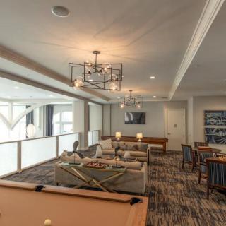 A modern game room featuring a pool table and cozy seating area.