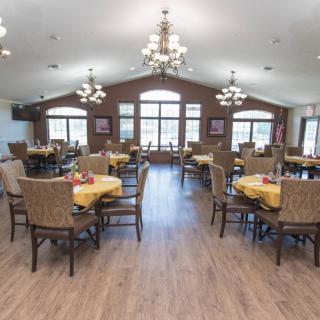 Spacious dining area with arranged tables and chandeliers.