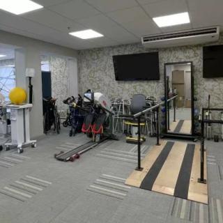 A modern rehabilitation gym equipped with exercise machines and therapy tools.