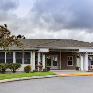 A single-story building with an entrance and cloudy skies above.