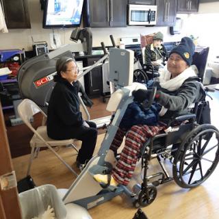 A patient engages in rehabilitation therapy with the assistance of a caregiver in a healthcare facility.