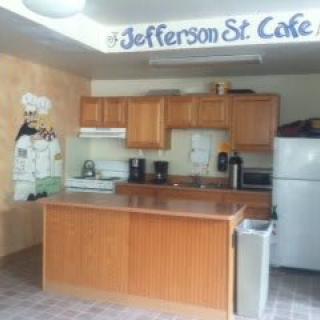A view of the Jefferson St. Cafe kitchen area with wooden cabinets and various appliances.