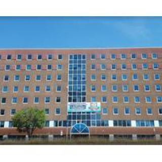 A modern office building with a brick facade and numerous windows.