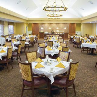 An elegant dining area with neatly arranged tables and chairs, set for a formal meal.