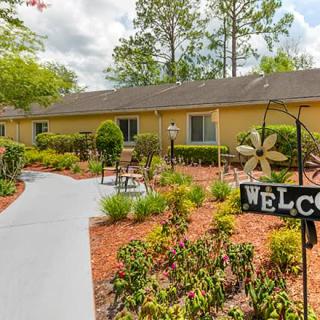 A welcoming garden path leading to a building, adorned with shrubs and landscaping.