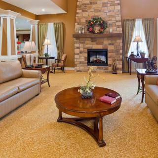A cozy living room with sofas, a wooden coffee table, and a stone fireplace.