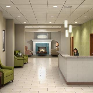 A modern lobby with a reception desk, comfortable seating, and a cozy fireplace.