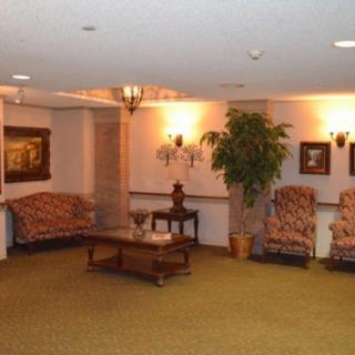 A cozy living room with sofas, chairs, a coffee table, and warm lighting.