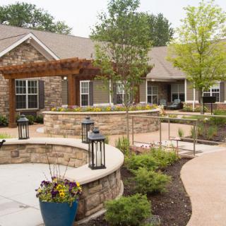 A beautifully landscaped residential garden with stone walls and pathways.