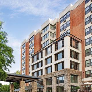 A modern residential building with a combination of brick and glass facade.