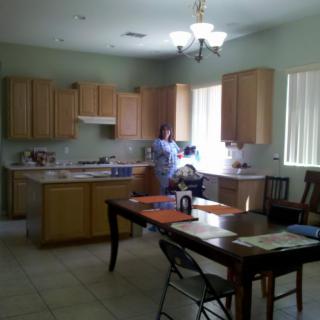 A well-lit kitchen with wooden cabinets and a dining table.