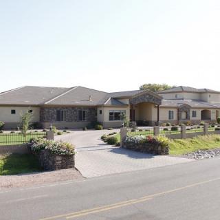 A large, modern single-story house with a spacious driveway and well-maintained landscaping.