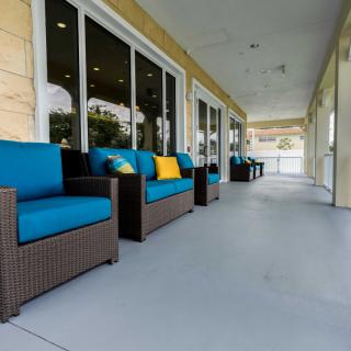 A spacious patio area featuring comfortable rattan furniture with blue cushions.