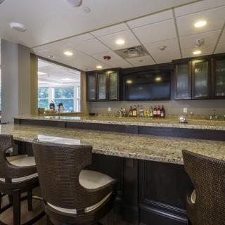 A modern bar with a granite countertop and comfortable seating.
