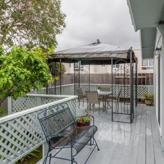 A cozy outdoor patio with a gazebo, seating area, and plants.
