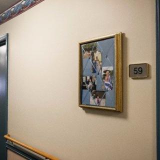 A hallway featuring a framed collage of photos next to a door with the room number 10.
