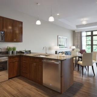 A modern open-concept kitchen with wooden cabinets, a central island, and stainless steel appliances.