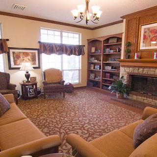 A cozy living room with a fireplace, bookshelves, and comfortable seating.