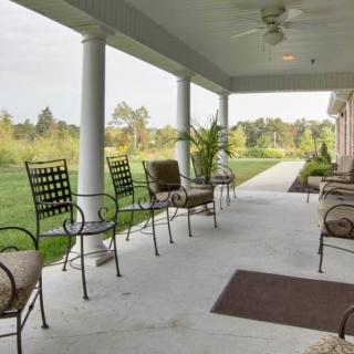 A spacious porch with comfortable seating and a view of the surrounding landscape.