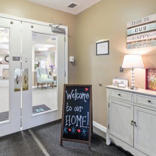 A cozy entrance with a 'Welcome to our home' sign and inviting decor.