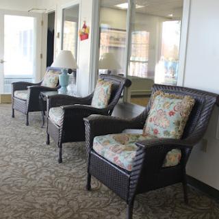 A cozy seating area featuring three stylish chairs with floral cushions.