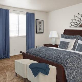 A cozy bedroom with blue accents and elegant decor.