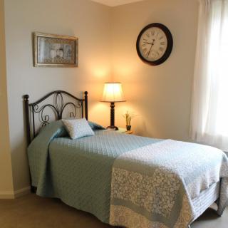 A cozy bedroom with a single bed, warm lighting, and decorative elements.