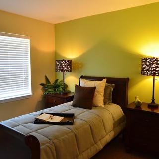 A cozy bedroom with a single bed and warm lighting.