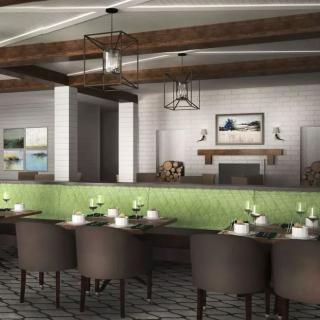 A modern restaurant interior featuring green upholstered seating and a cozy fireplace.