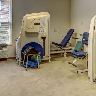 A small gym room with exercise machines and fitness equipment.