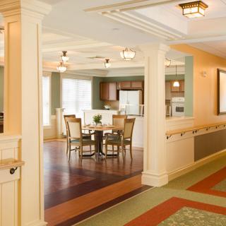 A modern interior featuring an open kitchen and dining area with wood flooring and elegant lighting.