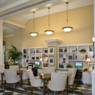 A modern office workspace with comfortable seating, desktop computers, and decorative shelving.