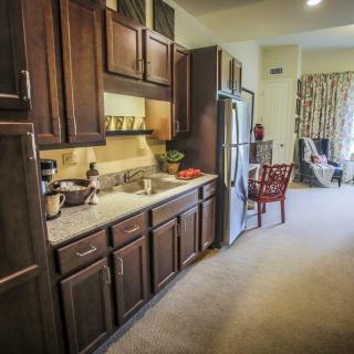 A modern kitchen interior with wooden cabinets and stainless steel appliances.