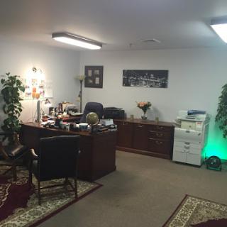 A well-organized office space featuring a desk, plants, and a printer.