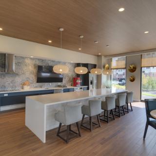 A modern kitchen with a large island and stylish pendant lighting.